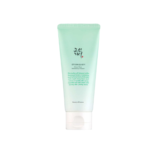 Tube of green skincare product on a white background